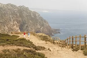 People walk along cliffs overlooking the Atlantic Ocean at Europes most westerly point at Cabo da Roca
