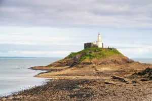 United Prints: People walking towards the Lighthouse at Mumbles Head during low tide in Swansea, Wales