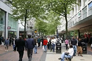 People walking down New Street, a pedestrian street with many shops. Birmingham