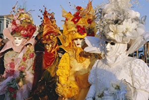 People wearing masked carnival costumes