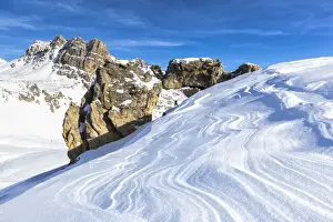 Graubunden Prints: One person and natural rock arch with snow shaped by the wind in the foreground