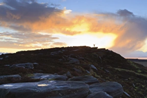 Hathersage Prints: Person on rocks of Stanage Edge with winter sunrise