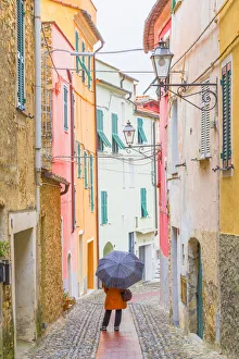 Liguria Prints: A person with an umbrella in the main street of Civezza, Province of Imperia, Liguria