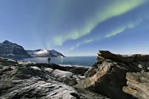 Photographer Prints: Photographer under the stars and Northern Lights (aurora borealis) surrounded by rocky peaks