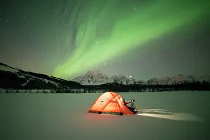 Photographer Prints: Photographer in a tent lit up by Northern Lights (aurora borealis) and starry sky