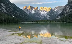 Photographer Prints: Photographer with tripod admiring the Dolomites at dawn from lake Landro, Dolomites