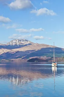 Loch Prints: Picturesque tranquil Loch Lomond with sailing boat, snow covered Beinn Uird behind