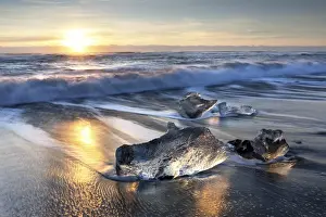 Black Sand Prints: Pieces of glacier ice washed up on black volcanic sand beach at sunrise, near Jokulsarlon