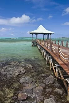 A pier is leading into the blue sea and ends in a small hut, Mauritius