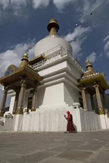 Pilgrim circling a white Stupa with prayer wheel in hand, Thimpu, Bhutan, Asia