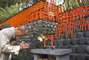 Bowing Prints: Pilgrim praying at altar with miniature orange toriis in background