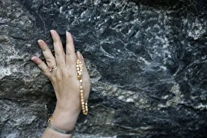 Touching Prints: Pilgrim touching the Lourdes grotto, Lourdes, Hautes Pyrenees, France, Europe