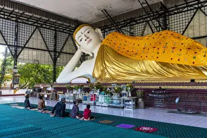 Pilgrims praying before a reclining Buddha, Su Taung Pyi pagoda, Myitkyina, Kachin state