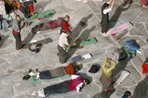 Tibetan Prints: Pilgrims prostrating in front square, Jokhang Buddhist temple, Lhasa, Tibet, China, Asia