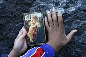 Touching Prints: Pilgrims touching the Lourdes grotto, Lourdes, Hautes Pyrenees, France, Europe