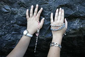 Touching Prints: Pilgrims touching the Lourdes grotto, Lourdes, Hautes Pyrenees, France, Europe