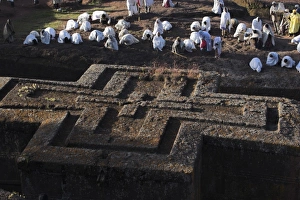 Pilgrims wearing traditonal gabi (white shawl) at festival at rock-hewn monolithic church of Bet Giyorgis (St. George s), roof shaped like a Greek cross, Lalibela, UNESCO World Heritage Site