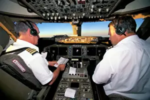 Uniform Prints: Pilots on flight deck of Jumbo Boeing 747 of Air New Zealand with sunrise ahead