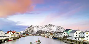 Nordland Prints: Pink Arctic sunrise over traditional houses in the fishing village of Henningsvaer in winter