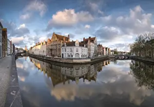 Bruges Prints: Pink clouds at dawn on the Belfry and historic buildings reflected in the typical canal