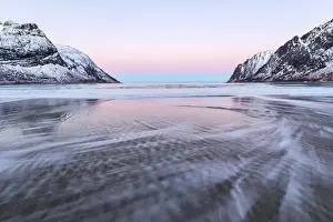 Motion Blur Prints: The pink light of sunrise over the waves of frozen sea surrounded by snowy peaks
