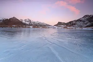 Blue Ice Prints: Pink lights of dawn on the snowy peaks around the frozen surface of Andossi Lake