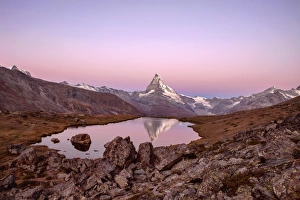 Pink sky at sunrise on the Matterhorn reflected in Stellisee, Zermatt, Canton of Valais