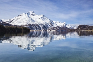 Piz da la Margna is reflected in the clear water of Lake Sils, Maloja Pass, Engadine