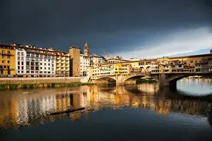 Ponte Vecchio Prints: Ponte Vecchio reflected in the Arno River against a dark blue stormy sky, Florence