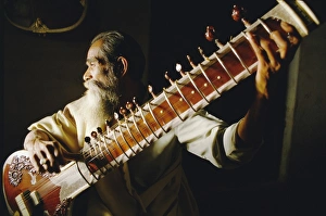 Only Men Prints: Portrait of an elderly man playing the sitar