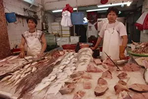 Two Men Prints: Portrait of two fishmongers at a stall with local fish for sale in a market in Hong Kong