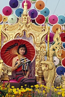 Portrait of a woman with umbrella seated on a golden