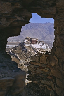 Potala Palace, UNESCO World Heritage Site, seen through ruined fort window Potala Palace, UNESCO World Heritage Site, seen through ruined fort window