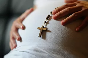 Pregnant woman with prayer beads, Paris, France, Europe