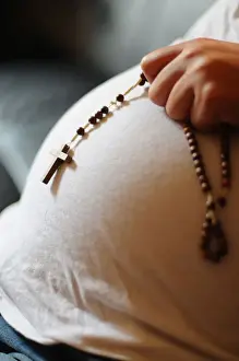 Pregnant woman with prayer beads, Paris, France, Europe
