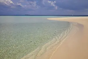 Gentle Prints: Pristine shallow waters lap against the white coral sand of a tropical beach; Havodda Island