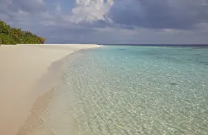 Warmth Prints: Pristine shallow waters lap against the white coral sand of a tropical beach; Havodda Island