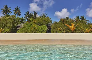 Crystal Prints: Pristine shallow waters lap against the white coral sand of a tropical beach; Havodda Island