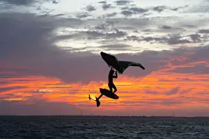 Young Man Prints: Pro surfer James Jenkins jumps his wing surfer at sunset over the Pamlico Sound at Nags