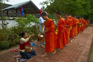 Procession of Buddhist monks collecting alms and rice at dawn, Luang Prabang