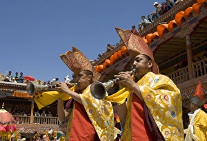 Procession in monastery courtyard with monk musicians