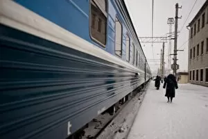 Providnistas remove snow and ice from the under the train, Trans-Siberian railway