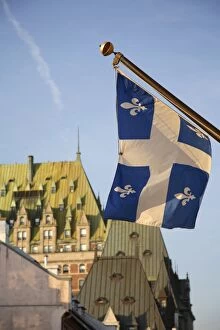 Quebec flag in foreground in front of rooftops of Chateau Frontenac, Quebec City
