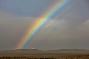 Rainbow Prints: A rainbow arches over a church in countryside near the town of Rif