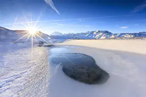 Braulio Valley Prints: Rays of sun on the frozen Lake, Piz Umbrail framed by Mount Ortles in background