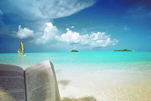 Images Dated 27th November 2009: Reading book on the beach, windsurfing and islands in the distance, the Maldives