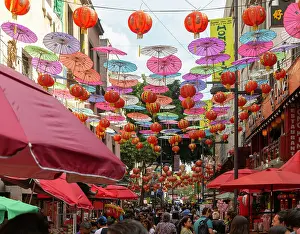 Stalls Prints: Red paper Chinese lanterns and umbrellas hanging above the street advertising various restaurants