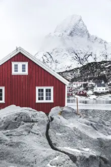 Olstind Prints: Red Rorbu in the frozen landscape with snowcapped Olstind mountain in the background