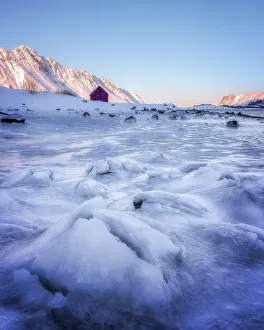 Nordland Prints: Red rorbuer hut set against a frozen lake, Lofoten Islands, Nordland, Norway, Europe