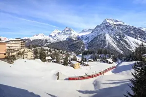Winter Scene Prints: Red train of Rhaetian Railway passes in the snowy landscape of Arosa, district of Plessur